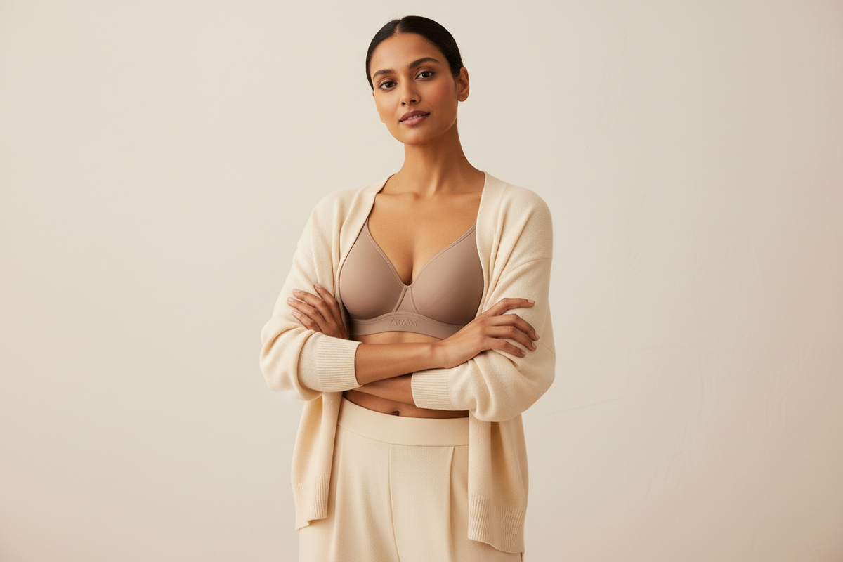 Modern Indian woman wearing a comfortable everyday bra under a soft neutral outfit, minimal background, clean lighting, premium lingerie brand aesthetic, confidence-focused pose, studio photography style
